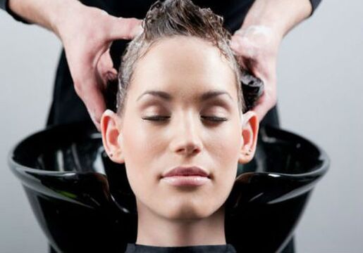 a una niña le aplican el producto mientras se pasa el pelo